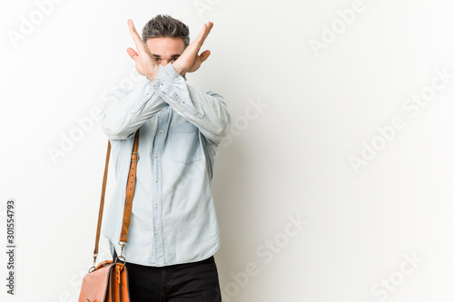 Young handsome business man keeping two arms crossed, denial concept.