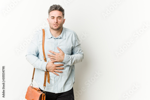 Young handsome business man sick, suffering from stomachache, painful disease concept.