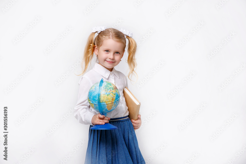 little girl in school uniform  on a white background hold globe