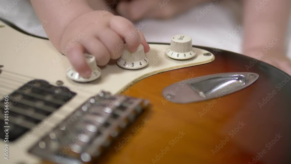 Little toddler boy playing with an electric guitar. hands closeup Little toddler boy playing with an electric guitar. hands closeup