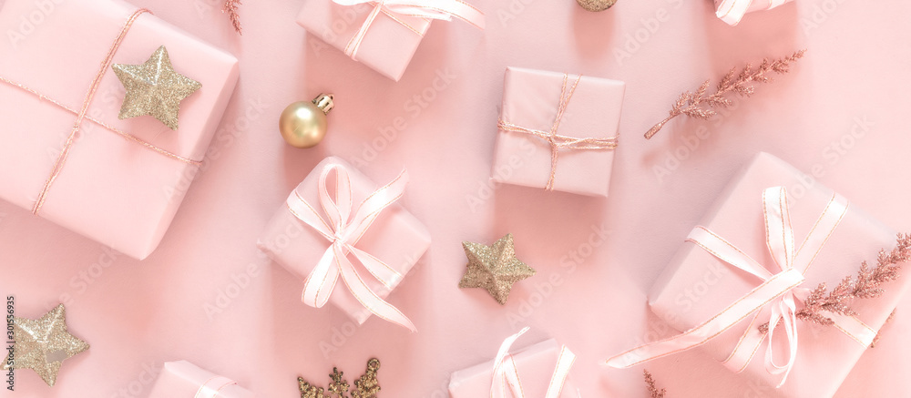 Christmas pink flat lay. Holiday boxes, fir branches on pink background. Christmas winter holiday congratulation invitation birthday wedding.Long banner - obrazy, fototapety, plakaty 