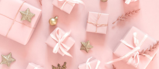 Christmas pink flat lay. Holiday boxes, fir branches on pink background. Christmas winter holiday congratulation invitation birthday wedding.Long banner