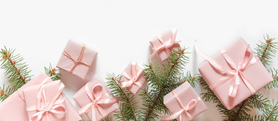 Christmas pink flat lay. Holiday boxes in pink packaging, fir branches on a light background. Christmas winter holiday congratulation invitation birthday wedding.Long banner