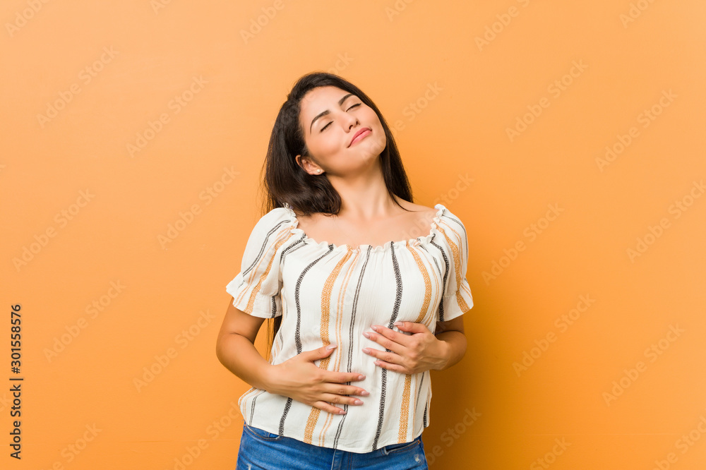 Young curvy woman touches tummy, smiles gently, eating and satisfaction concept. Young curvy woman touches tummy, smiles gently, eating and satisfaction concept.