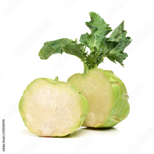 A vertical picture of a pretty two toned green kohlrabi with gracefully furled leaves on an isolated white background.