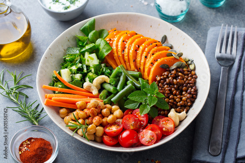 Healthy vegetarian salad. Buddha bowl. Grey background. Close up.