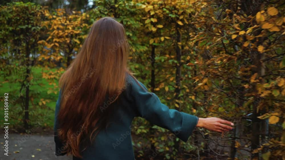 Beautiful girl walking in garden labyrinth on autumn day Beautiful girl walking in garden labyrinth on autumn day