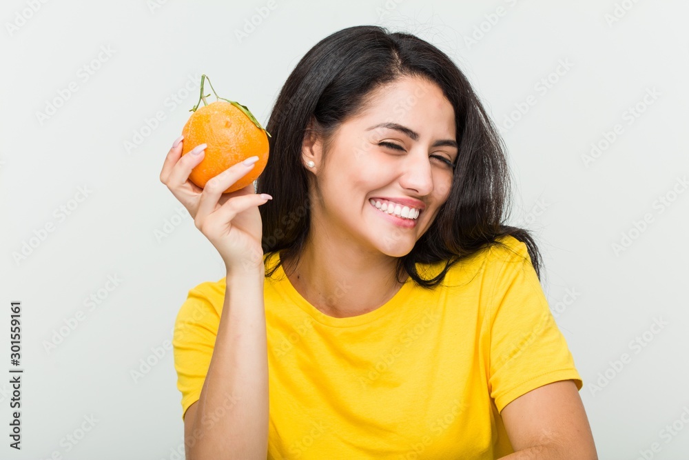Young hispanic woman drinking an orange juice with a straw Young hispanic woman drinking an orange juice with a straw