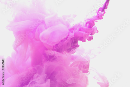 Abstract flowing liquid or violet ink in water on a white background. It looks like smoke or cloud. Or zero gravity. photo