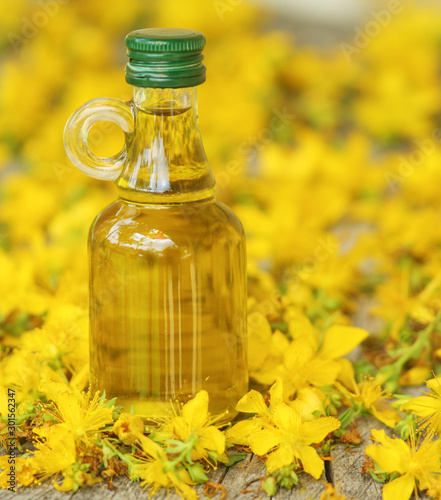 Oil in a glass bottle  with a background of St. John s wort
