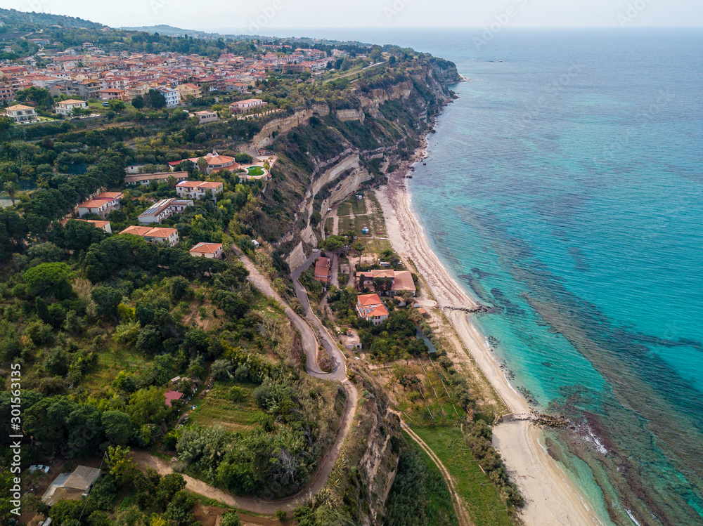 Aerial view of the Calabrian coast, villas and resorts on the cliff. Transparent sea and wild coast. Locality of Riaci near Tropea, Calabria. Italy