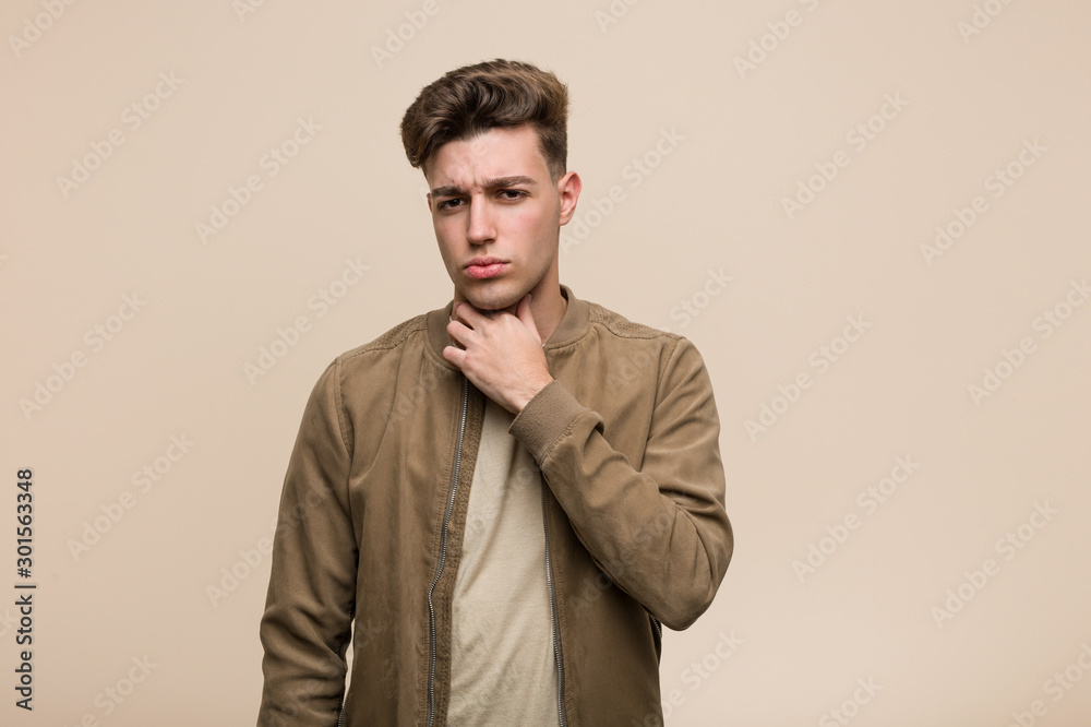 Young caucasian man wearing a brown jacket suffers pain in throat due a virus or infection. Young caucasian man wearing a brown jacket suffers pain in throat due a virus or infection.