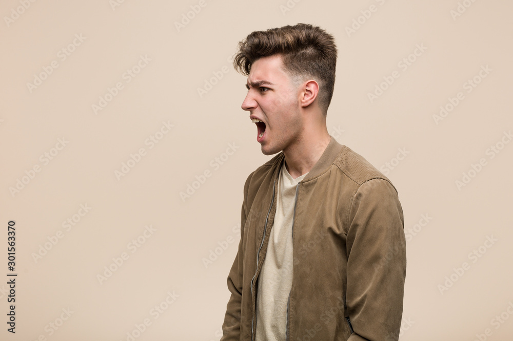 Young caucasian man wearing a brown jacket shouting towards a copy space Young caucasian man wearing a brown jacket shouting towards a copy space