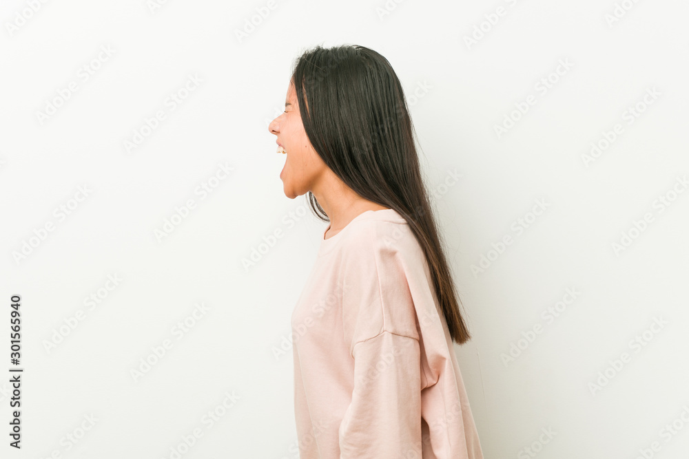 Young cute hispanic teenager woman shouting towards a copy space Young cute hispanic teenager woman shouting towards a copy space