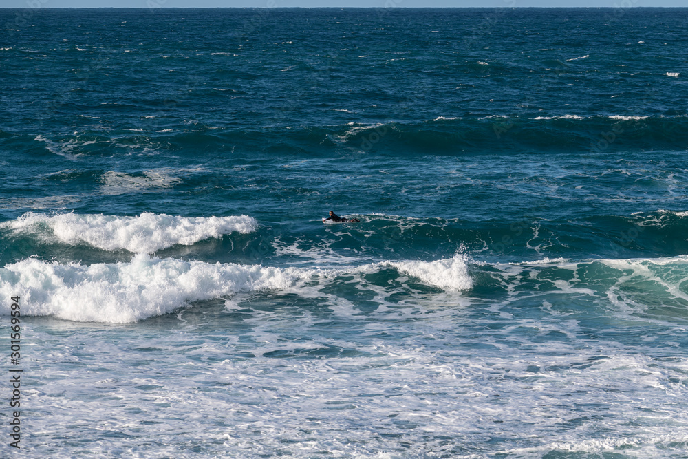 A lone surfer in the distance