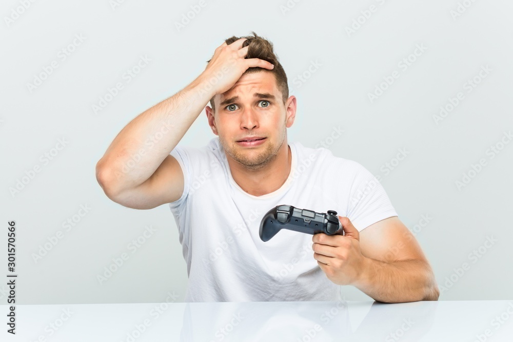 Young man holding a game controller being shocked, she has remembered important meeting. Young man holding a game controller being shocked, she has remembered important meeting.