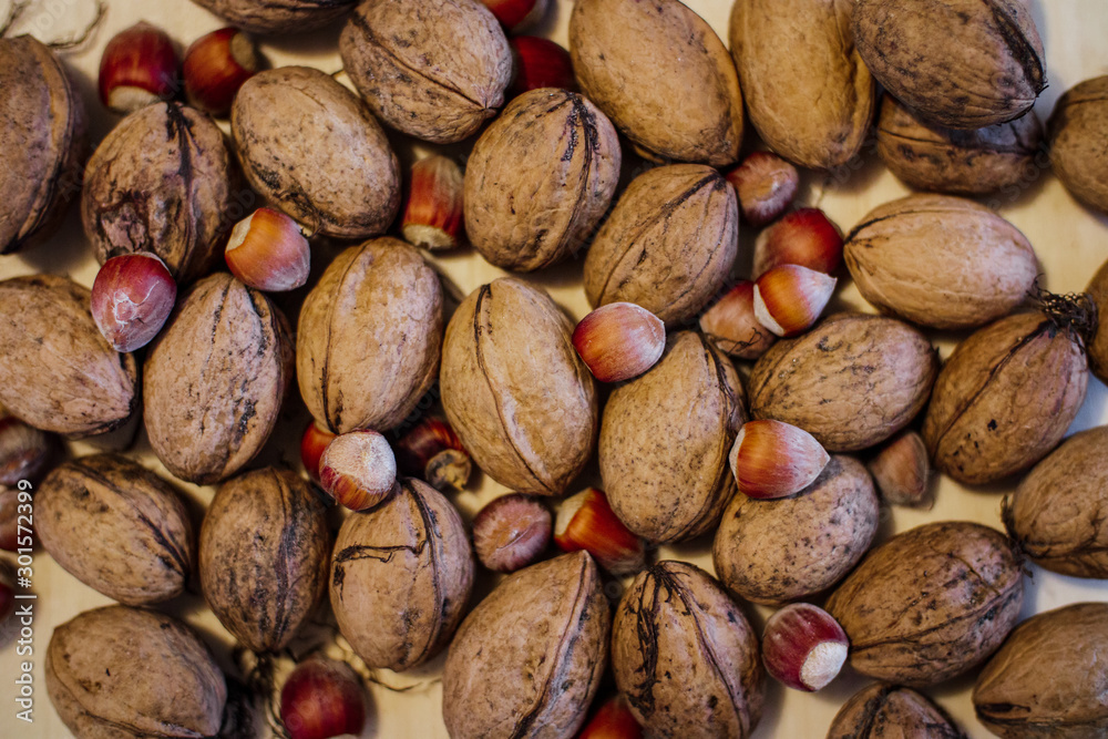 Flat lay photo pf walnuts and hazelnuts on light wood. Flat lay, top view. Flat lay photo pf walnuts and hazelnuts on light wood. Flat lay, top view.