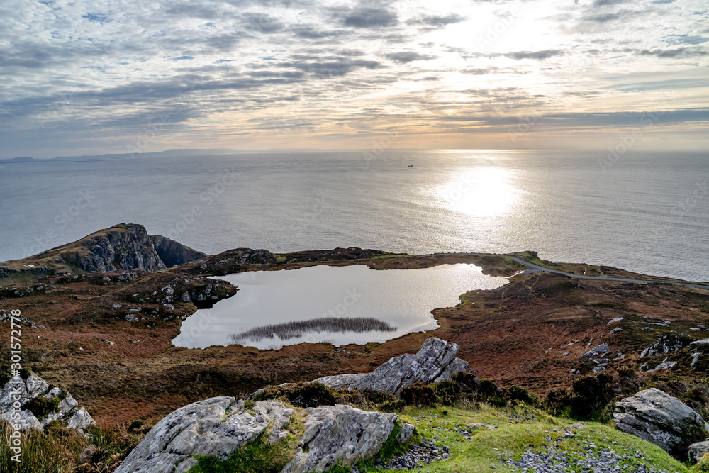 Sunset above the lake at Slieve League Cliffs which are among the highest sea cliffs in Europe rising 1972 feet above the Atlantic Ocean - County Donegal, Ireland.