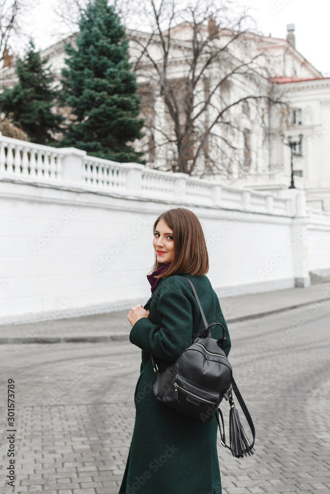 Beautiful young stylish brunette woman wearing midi green coat