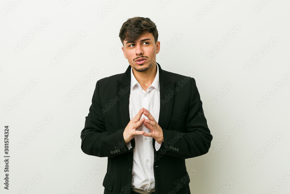 Young business hispanic man making up plan in mind, setting up an idea. Young business hispanic man making up plan in mind, setting up an idea.