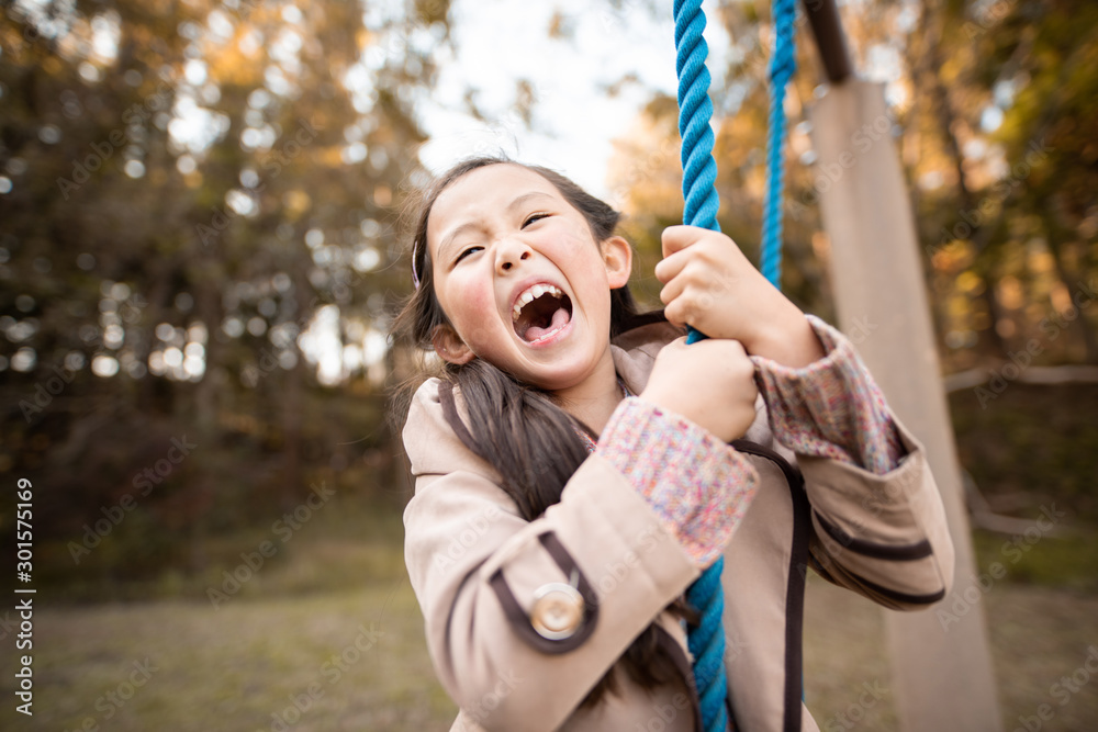 Obraz premium 秋の公園で遊ぶ笑顔の女の子