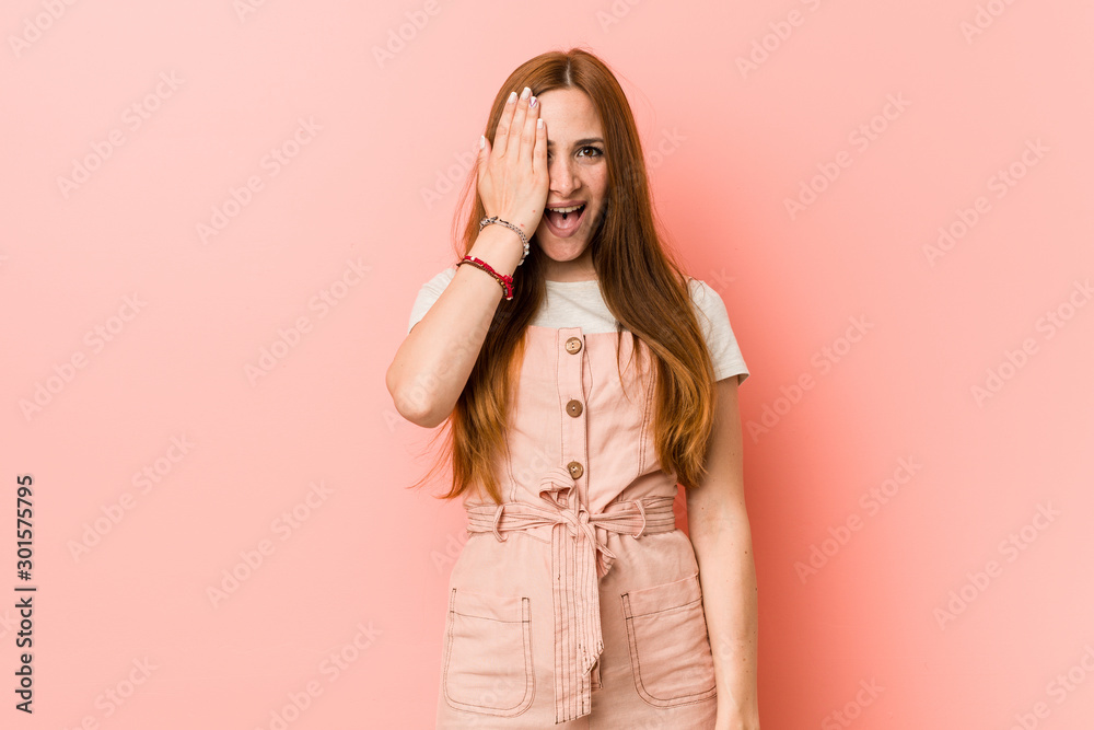 Εκτύπωση καμβά Young ginger woman with freckles having fun covering half of face with palm