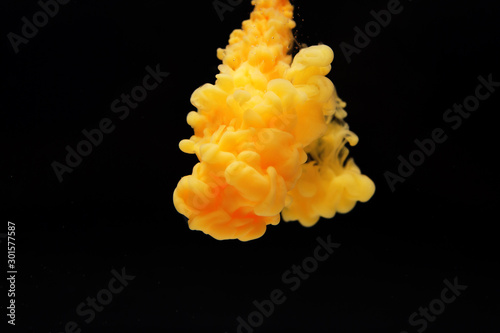 Obraz na plátně Abstract flowing liquid or orange color ink in water on a black background