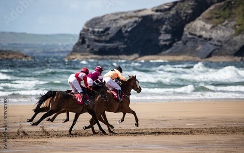Race horses and jockeys racing by the coastal cliffs on the west coast of Ireland