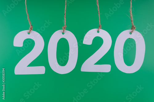 the date of the new twentieth twentieth year is highlighted in closeup from the numbers hanging on the ropes on a green background