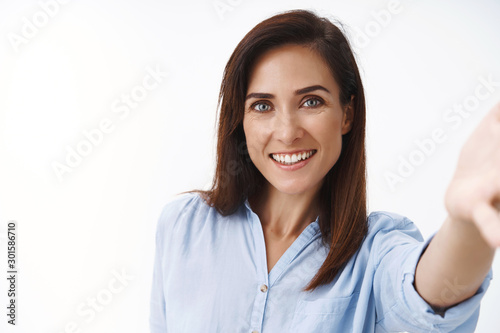 Close-up good-looking tender friendly pretty middle-aged 30s woman extend arm, hold camera in hand and smiling broadly, taking selfie, photographing, record video-message, calling husband © Cookie Studio