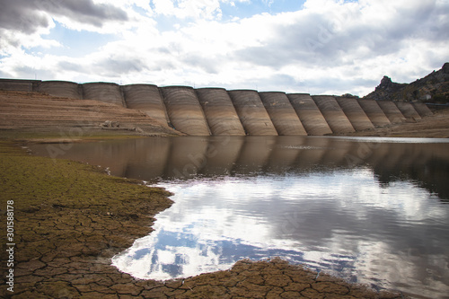 Dam and a small lake in an arid dried out ground. photo