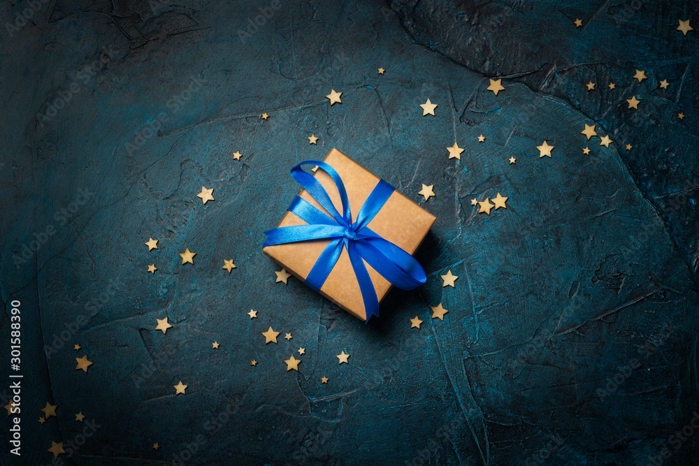 Gift box on a dark blue stone background with stars. Gift concept for a loved one, night. Flat lay, top view - obrazy, fototapety, plakaty 