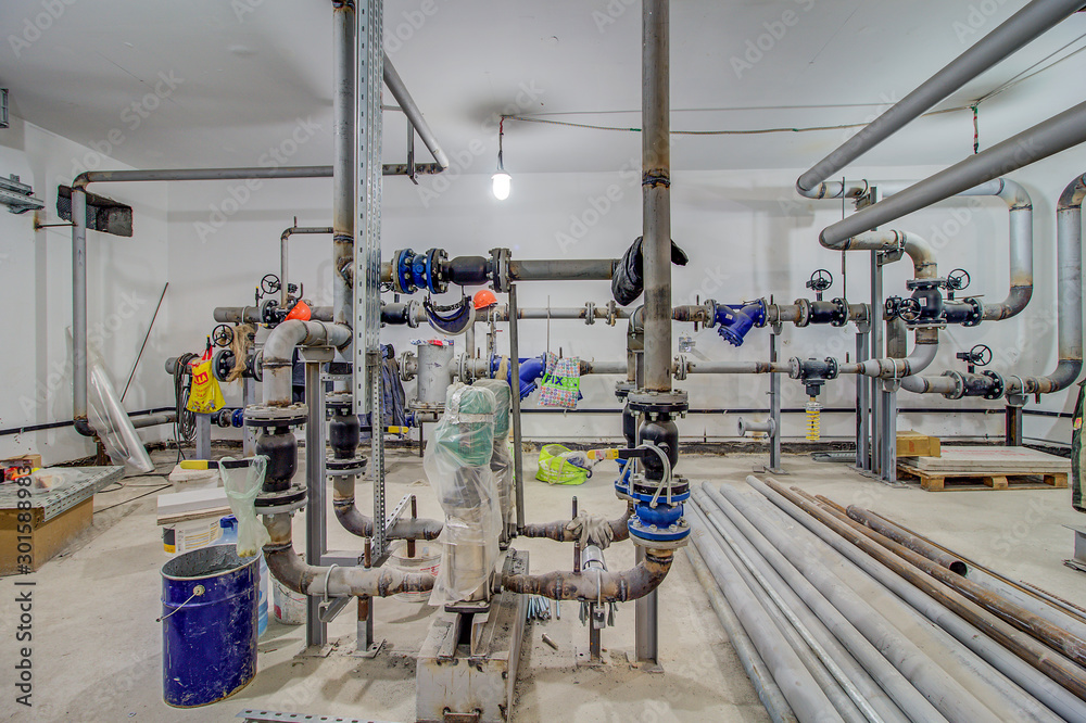 pumping station under construction. pipes of central heating system and  water pipes with thermal insulation. Electric motor water pump under repair  process at power plant. Industrial zone. Photos | Adobe Stock