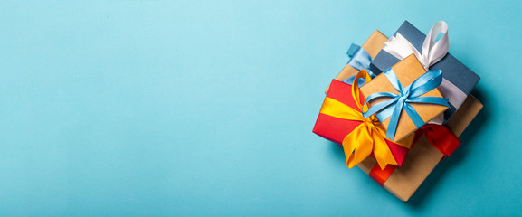 Stack of gifts on a blue background. Gift concept for a loved one, holiday, Christmas. Banner. Flat lay, top view