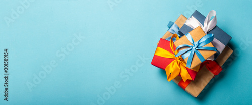 Stack of gifts on a blue background. Gift concept for a loved one, holiday, Christmas. Banner. Flat lay, top view photo