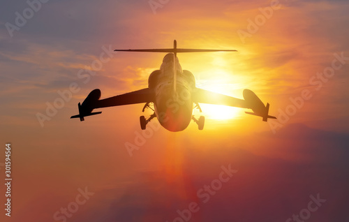 Night flight. Military Airplane in the sky at sunset
