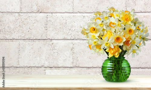 Photo bouquet of yellow daffodils on a light background of a wall of blocks