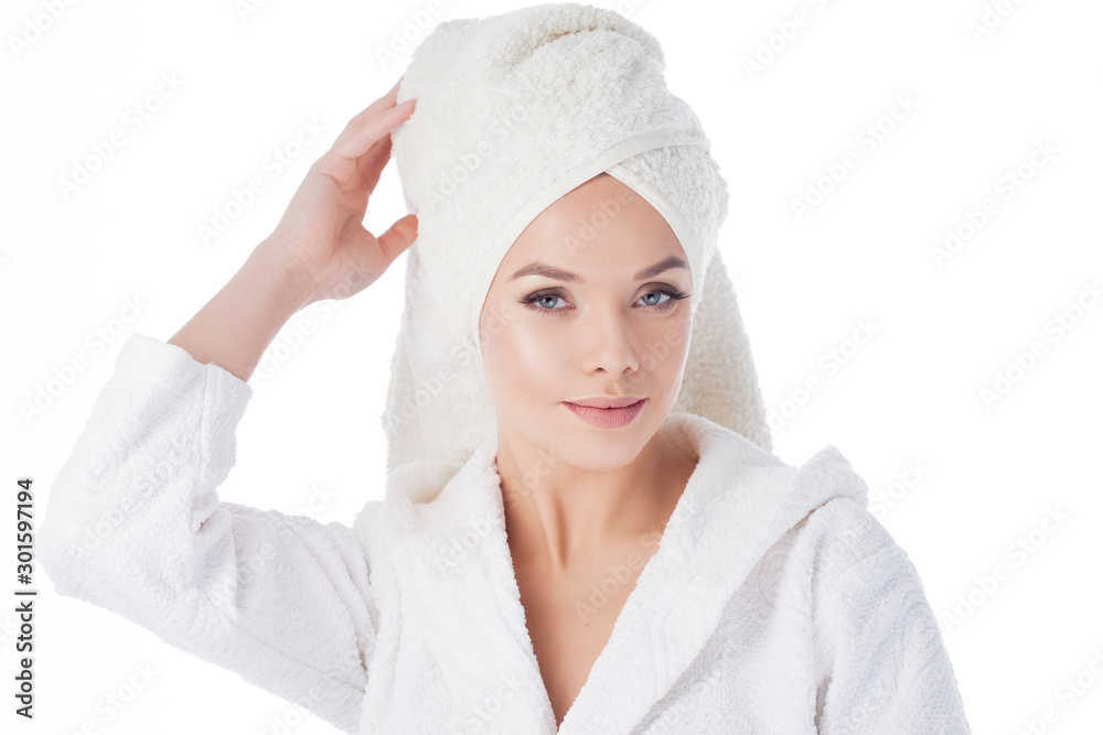 Beauty treatments after the bath. Portrait of a young beautiful woman in a Terry robe and with a towel on her head. Beauty treatments after the bath. Portrait of a young beautiful woman in a Terry robe and with a towel on her head.
