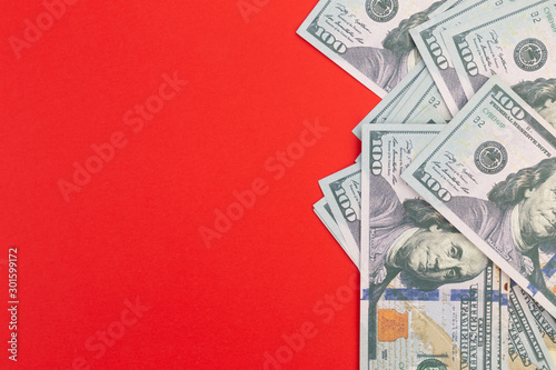 United States or USA 100 dollar currency on a red background and copy space.  Fake money and financial fraud concept.