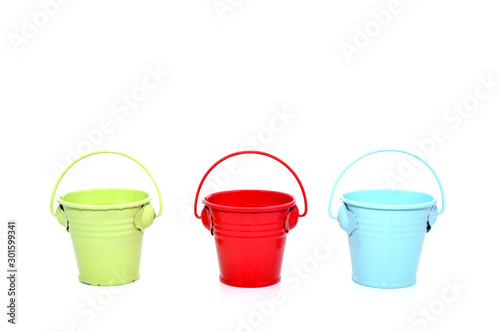 Three metal buckets of different colours with handle © mixeey