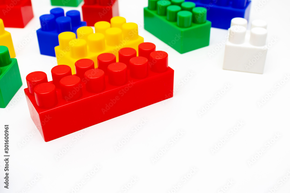 Many colorful toy plastic bricks, kit of blocks for building and constructing on white background with copy space Many colorful toy plastic bricks, kit of blocks for building and constructing on white background with copy space