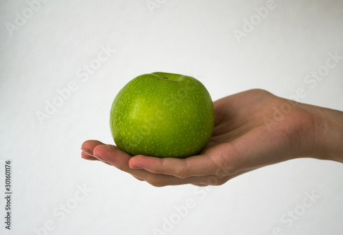 Big green apple in the hand.