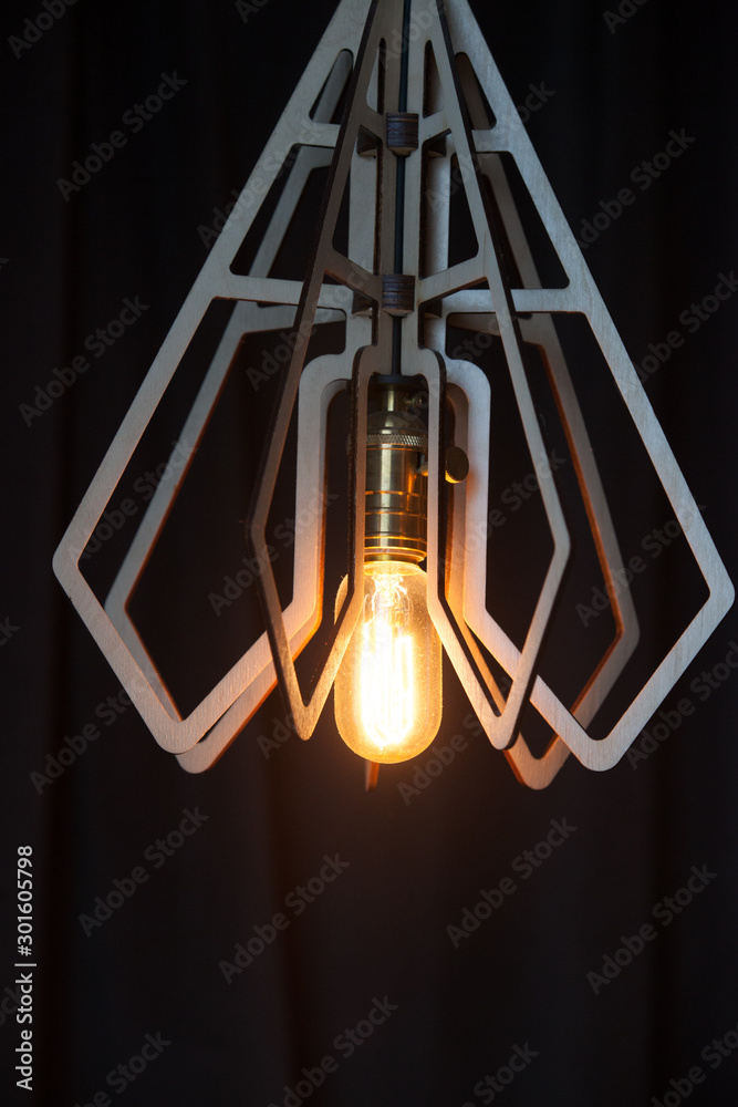Decorative antique Edison style light bulb against a brown wall background