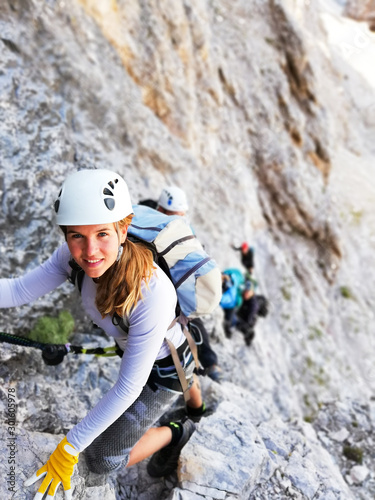 attractive female mountain climber on a steep and hard Via Ferrata climb in the Italian Dolomites