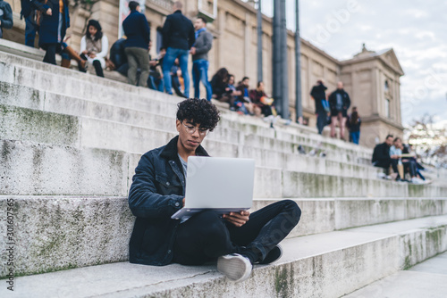 Photography Handsome male digital nomad working remotely in Barcelona creating trip guide fo