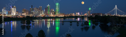 Dallas skyline reflecting in river with full moon