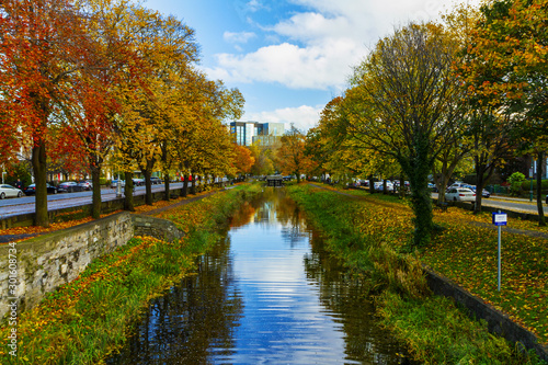 View from Huband Bridge Grand Canal Dublin with colorful Autumn / fall foliage, showing towpaths along canal banks, trees and grass. Canal lock C3 photo