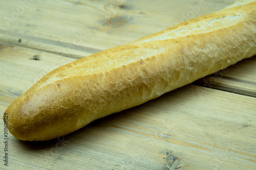 French baguette. Freshly baked traditional french bread on a wooden table.
