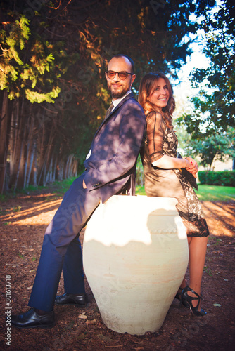 Couple embraced in a garden, sitting on a anphora photo