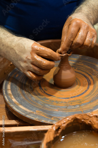 hands that shape the clay pottery Turning